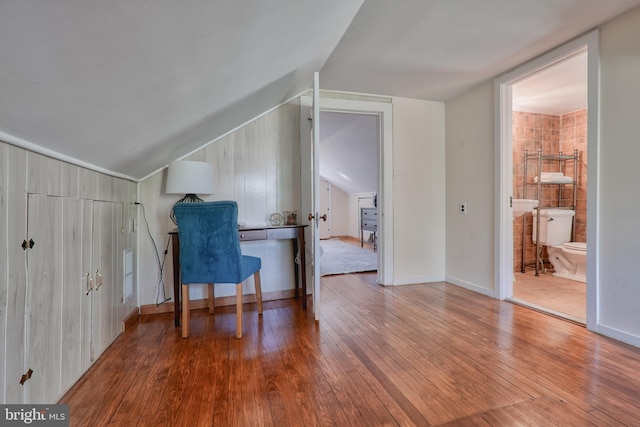 home office with vaulted ceiling, baseboards, and light wood-style floors