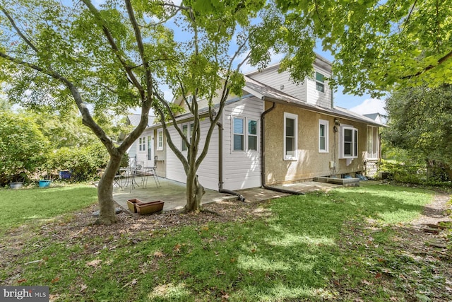 rear view of house featuring a patio area and a lawn