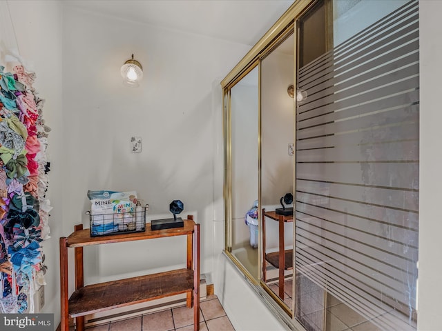 bathroom with tile patterned flooring and combined bath / shower with glass door