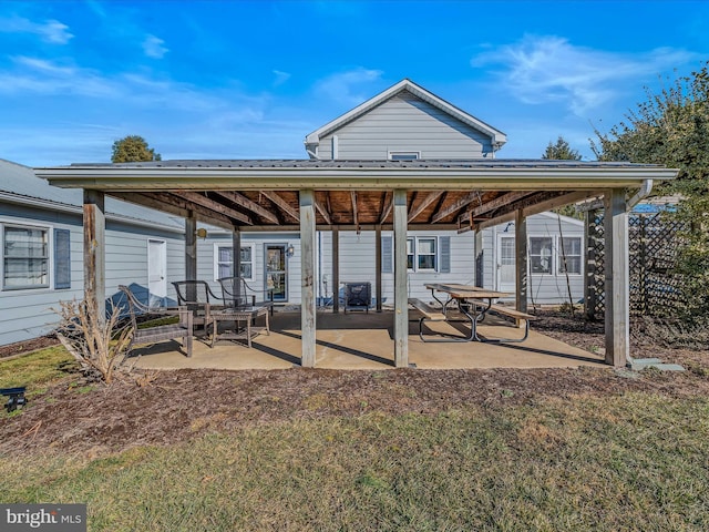 rear view of house with a patio and a lawn