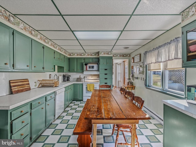 kitchen featuring sink, a drop ceiling, white appliances, and green cabinetry