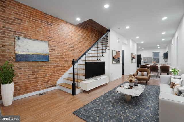 living room featuring brick wall and hardwood / wood-style floors