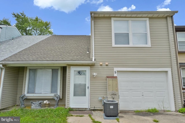 view of front of house featuring a garage and central air condition unit