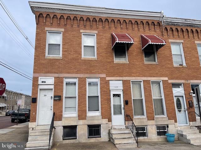 townhome / multi-family property with entry steps and brick siding