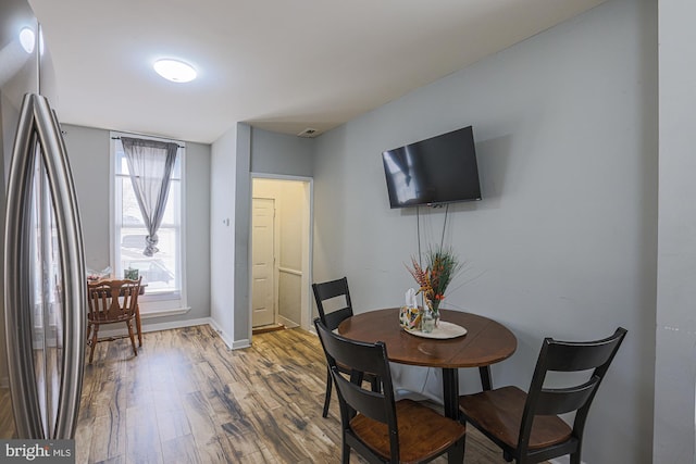 dining room with wood finished floors, visible vents, and baseboards