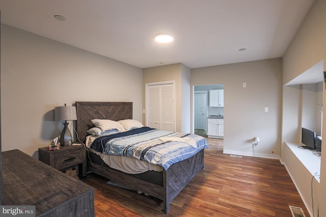 bedroom featuring wood finished floors, visible vents, and baseboards