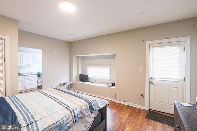 bedroom with light wood-style flooring and baseboards