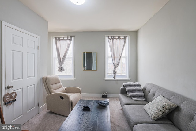 living area with plenty of natural light, baseboards, and carpet flooring