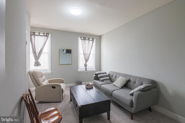 carpeted living room featuring baseboards