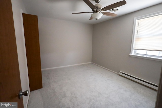 spare room with ceiling fan, a baseboard radiator, and light carpet