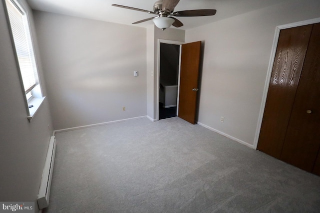 unfurnished bedroom with ceiling fan, carpet, and a baseboard heating unit