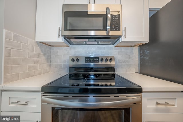 kitchen featuring backsplash, appliances with stainless steel finishes, and white cabinets