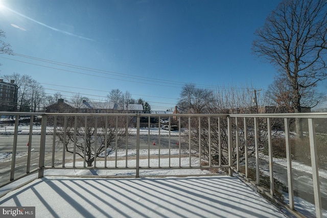 view of snow covered back of property