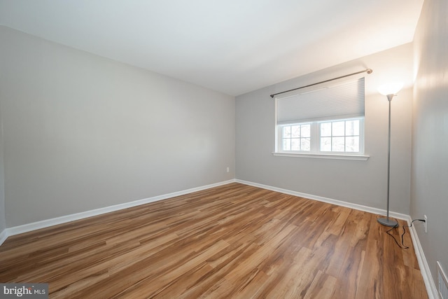 unfurnished room with hardwood / wood-style flooring