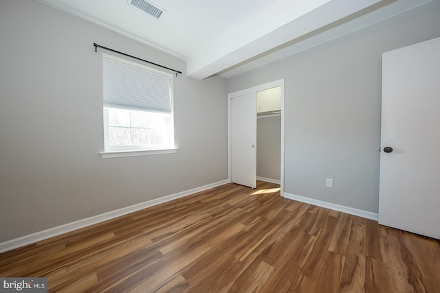 unfurnished bedroom featuring dark wood-type flooring and a closet