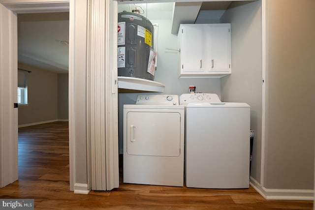 washroom featuring cabinets, wood-type flooring, electric water heater, and washing machine and clothes dryer