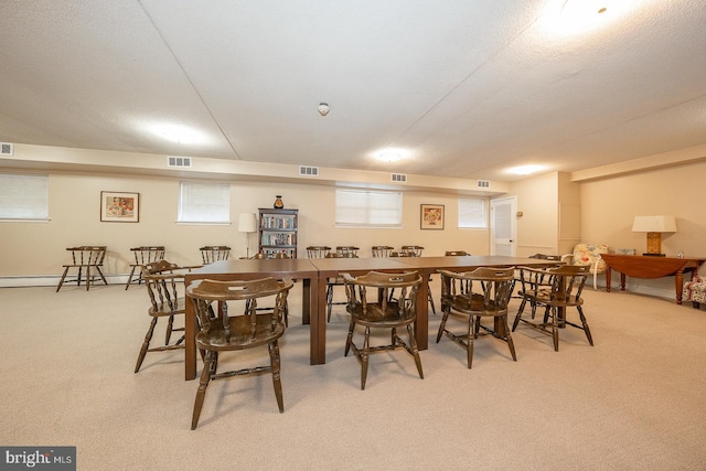 carpeted dining space featuring baseboard heating