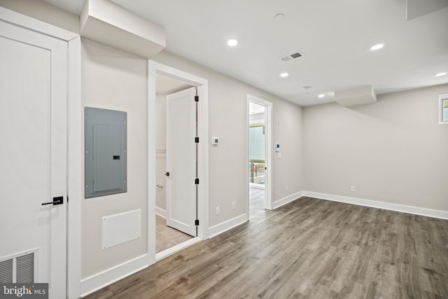 basement with electric panel and light wood-type flooring