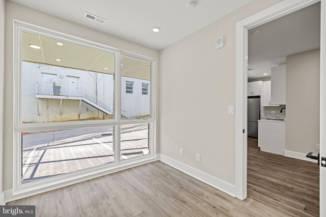 empty room with sink and light hardwood / wood-style floors