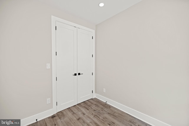 unfurnished bedroom featuring a closet and light wood-type flooring