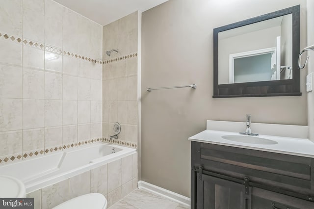 full bathroom with tiled shower / bath, vanity, and toilet