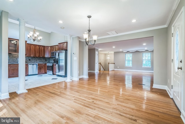 kitchen featuring ornate columns, an inviting chandelier, light wood-type flooring, stainless steel appliances, and backsplash