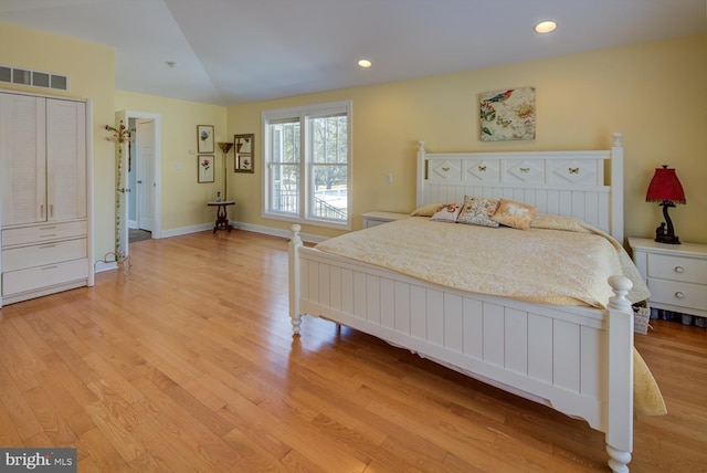 bedroom with lofted ceiling and light hardwood / wood-style flooring