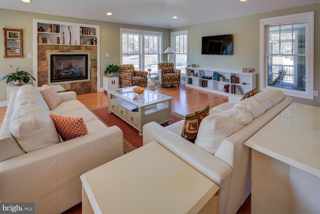 living room with plenty of natural light, a tile fireplace, and light wood-type flooring