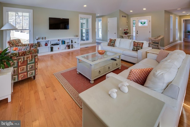 living room with vaulted ceiling and light wood-type flooring