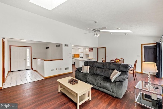 living room with hardwood / wood-style flooring, lofted ceiling with skylight, and ceiling fan