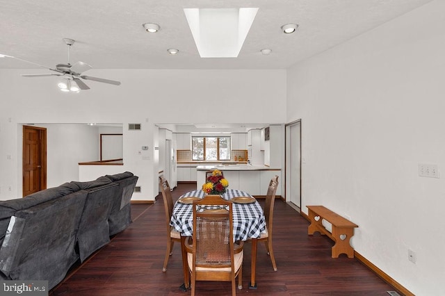 dining area featuring ceiling fan, dark hardwood / wood-style flooring, and a skylight