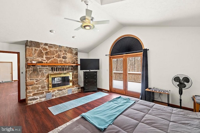 bedroom with lofted ceiling, ceiling fan, a fireplace, wood-type flooring, and access to outside