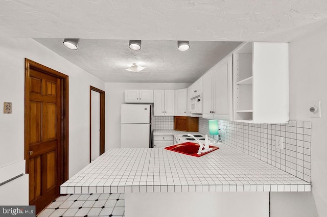 kitchen featuring sink, white appliances, white cabinetry, backsplash, and kitchen peninsula