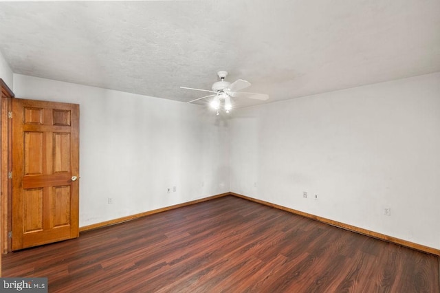 spare room with dark wood-type flooring, a textured ceiling, and ceiling fan