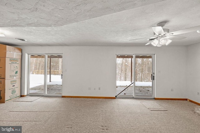 empty room featuring ceiling fan, carpet floors, and a textured ceiling