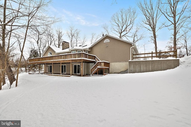 view of snow covered back of property