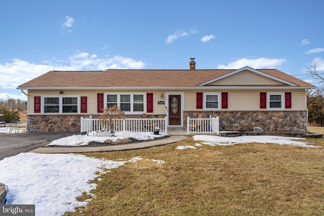 ranch-style home with a porch and a yard