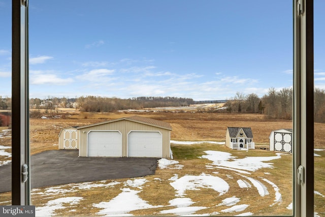 exterior space featuring an outbuilding, a garage, and a rural view