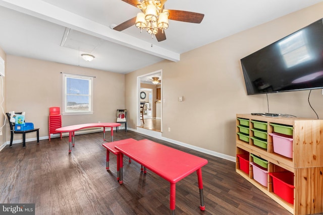 game room with dark wood-type flooring, ceiling fan, and beam ceiling