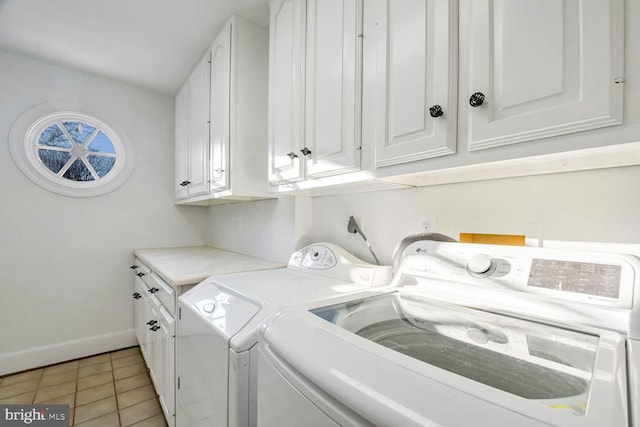 clothes washing area featuring cabinets, light tile patterned floors, and independent washer and dryer