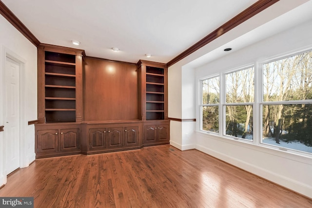 unfurnished living room featuring crown molding and hardwood / wood-style floors