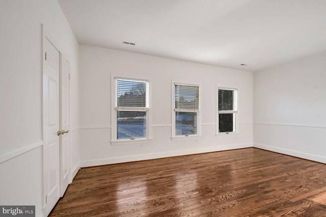 empty room with dark hardwood / wood-style flooring