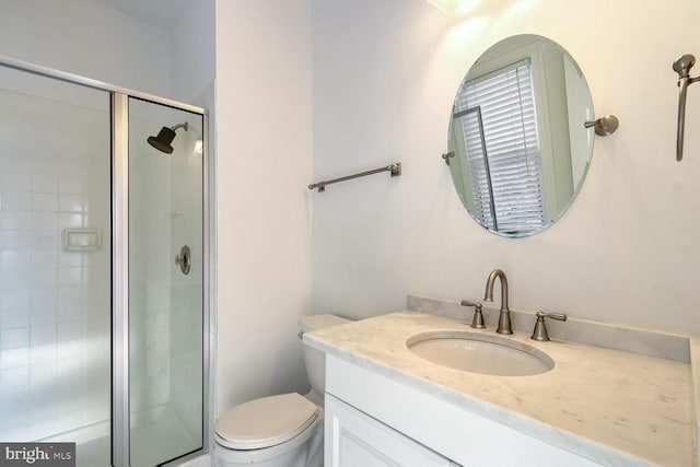 bathroom with vanity, an enclosed shower, and toilet