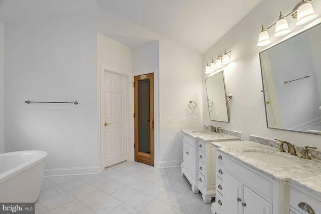 bathroom featuring lofted ceiling, vanity, and a bathtub