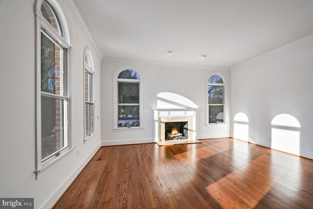 unfurnished living room featuring hardwood / wood-style flooring, ornamental molding, and a fireplace