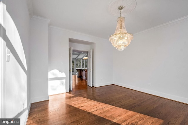 unfurnished room with dark wood-type flooring, ornamental molding, and a chandelier