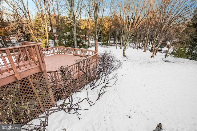 yard covered in snow featuring a deck