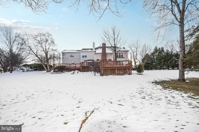 snow covered house with a wooden deck