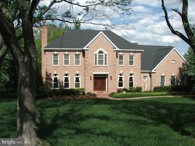 colonial inspired home featuring a front yard