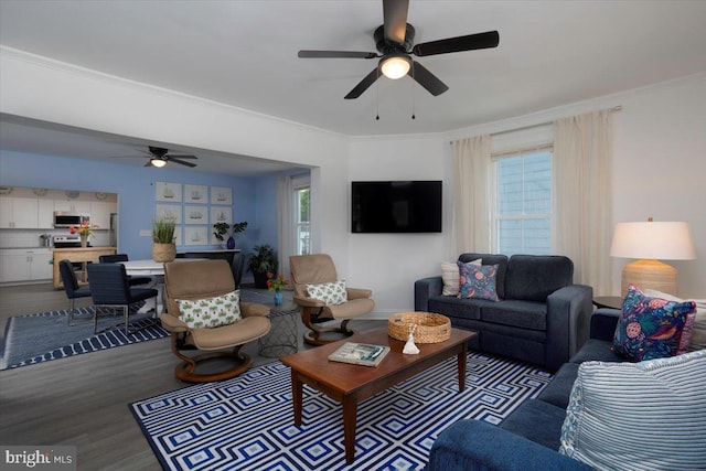 living room with hardwood / wood-style flooring, ornamental molding, and ceiling fan